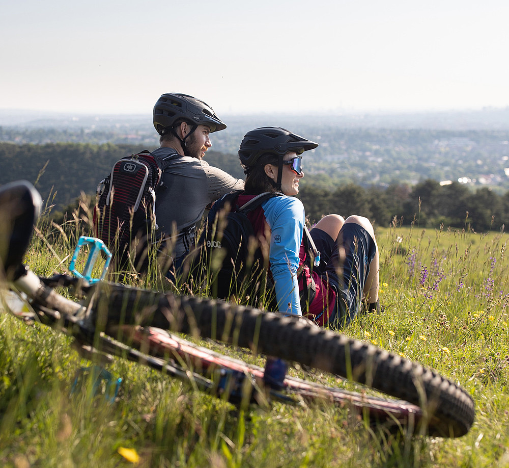 Mountainbike im Vordergrund, Radfahrer sitzen dahinter