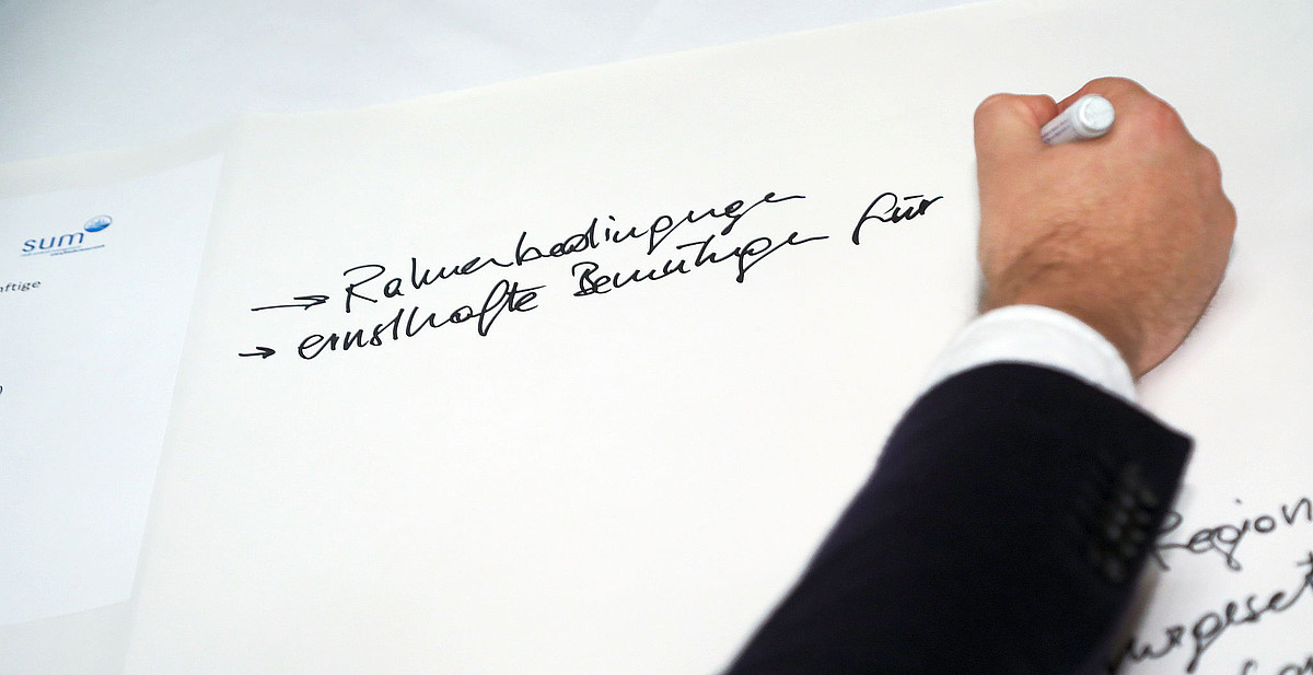 Hand schreibt auf Flipchart